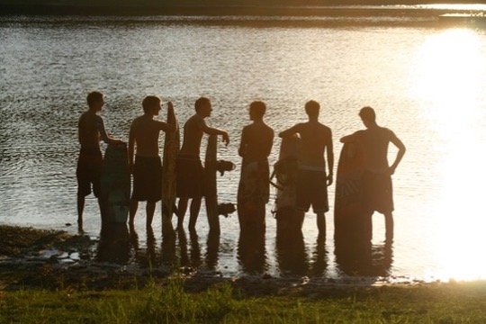 Friends at the water's edge at sunset